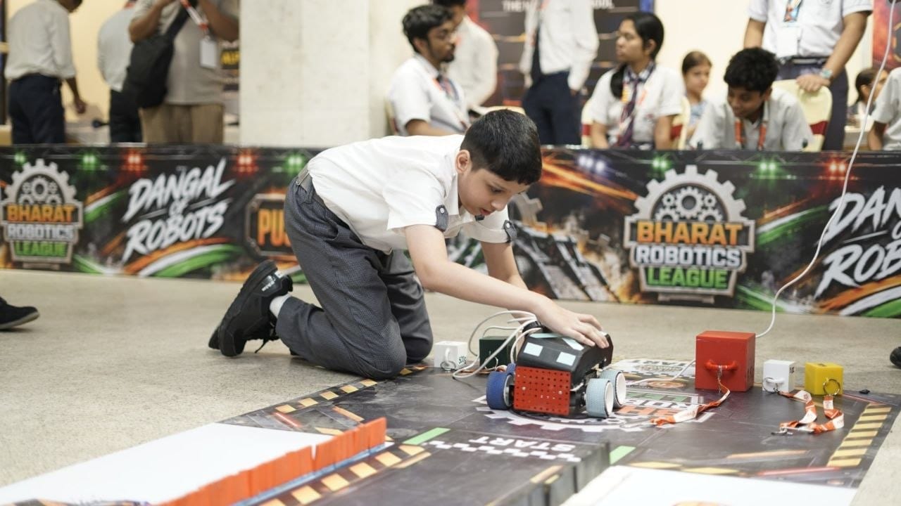 A student placing his robot at the start line of a Bharat Robotics League arena